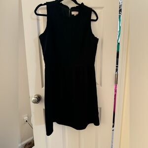 Little black dress. Ruffle around arm/neck. Fit and flare.